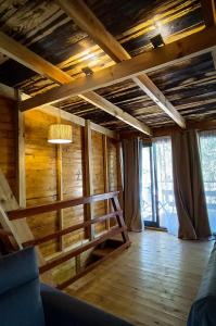 Habitación con suelo de madera y techo con lámpara de araña. en Quinta Alma - Ecological Retreat Farm en Aljezur