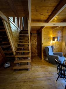 a wooden staircase in a room with a couch and a chair at Quinta Alma - Ecological Retreat Farm in Aljezur
