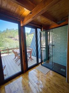 Habitación con puertas correderas de cristal y una mesa en una terraza. en Quinta Alma - Ecological Retreat Farm, en Aljezur