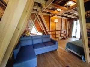 a living room with a blue couch and a bed at Quinta Alma - Ecological Retreat Farm in Aljezur