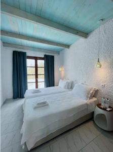 ein Schlafzimmer mit einem großen Bett mit blauer Decke in der Unterkunft Poseidon Blue Gastronomy Hotel in Afiartis