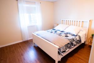 a white bed in a room with a window at L'Évasion in Lambton