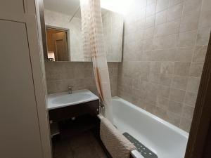 a bathroom with a sink and a bath tub at Studio Résidence Glières in Bourg-Saint-Maurice +6 photos