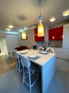 a kitchen with a island with chairs and red cabinets at Luxury Gated Apartment in Sofia