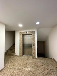 an empty hallway with a glass door and stairs at Luxury Gated Apartment in Sofia