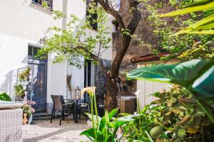 patio ze stołem, krzesłami i drzewem w obiekcie Appartement très cosy avec cour w Cannes
