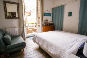 sypialnia z łóżkiem, krzesłem i lustrem w obiekcie Appartement très cosy avec cour w Cannes