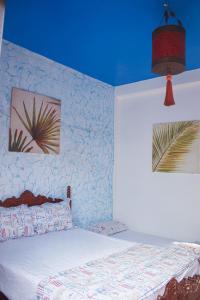 a bedroom with a bed and two pictures on the wall at Happy Home Dream Surf in Imsouane