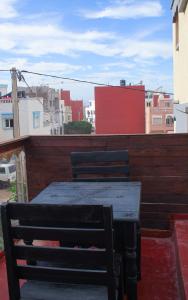 una mesa de madera y una silla en un balcón con edificios en Happy Home Dream Surf, en Imsouane