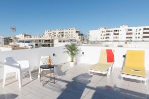 eine Gruppe Stühle und ein Tisch auf dem Dach in der Unterkunft Villa Marquez Apartments in Vila Real de Santo António