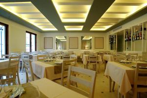 a dining room with tables and chairs with white tablecloths at Hotel La Fonda Moreno in Morella