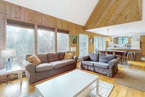 sala de estar con sofá y mesa en Vermont Country Ski House, en Vermont Ventures