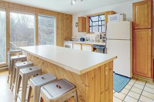 a kitchen with a white refrigerator and stools at Vermont Country Ski House in Vermont Ventures