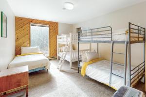 1 dormitorio con 2 literas y ventana en Vermont Country Ski House, en Vermont Ventures