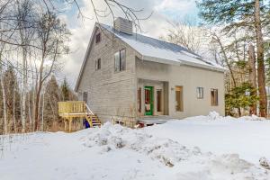 una casa con una puerta verde en la nieve en Vermont Country Ski House, en Vermont Ventures