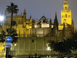 een groot gebouw met 's nachts een klokkentoren bij Apartamento Santa cruz in Sevilla