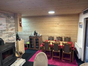 une salle à manger avec une table, des chaises et une cheminée dans l'établissement Vikendice Jahorinska Dvorišta, à Pale