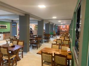 a dining room with wooden tables and chairs at Tamandaré Praia Hotel in Tamandaré