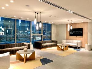 uma sala de estar com mobiliário de couro e uma grande janela em Luxurious 1-bedroom With Skyline View In Downtown Views Ii em Dubai