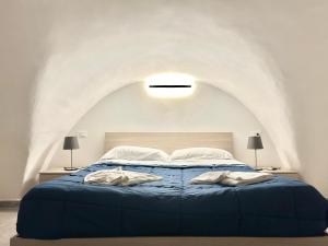 1 dormitorio con 1 cama azul y 2 toallas en Élite, en Gaeta