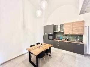a kitchen with a wooden table and black chairs at Élite in Gaeta