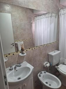 a bathroom with a sink and a toilet and a mirror at Departamento 1ero de Mayo (Santa Fe) in Santa Fe