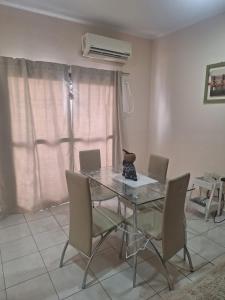 a dining room with a glass table and chairs at Departamento 1ero de Mayo (Santa Fe) in Santa Fe