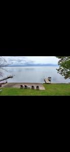a group of benches sitting next to a body of water at Luxury Lakehouse on Oneida Lake in Blossvale
