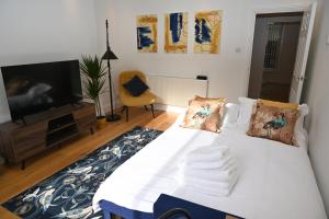 ロンドンにあるLittle Venice UK Bright & Stylish garden apartmentのベッドルーム(白いベッド1台、テレビ付)