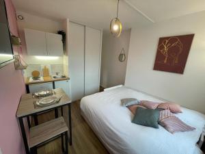 um pequeno quarto com uma cama e uma mesa em Studio proche centre ville em Caen