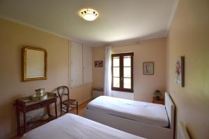 a bedroom with two beds and a mirror and a table at Ancienne gare rénovée - Clévacances 2 Clés in Réaup