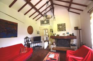 a living room with a red couch and a fireplace at Ancienne gare rénovée - Clévacances 2 Clés in Réaup