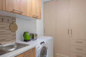 a kitchen with a washing machine and a sink at Renovated and cozy apartment close to metro in Athens