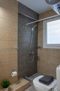 a bathroom with a shower with a toilet and a window at Renovated and cozy apartment close to metro in Athens