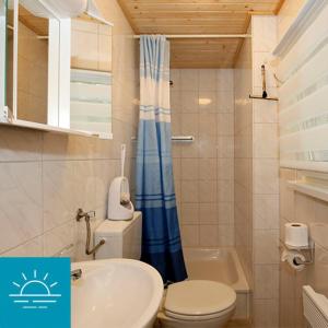 ein kleines Bad mit WC und Waschbecken in der Unterkunft Bungalow SONNE UND MEER direkt am Strand in Dranske