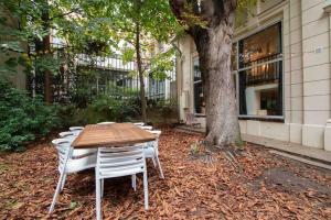 drewniany stół i krzesła obok drzewa w obiekcie Secret APT with Garden 6/8P Montmartre Sacré-Coeur w Paryżu
