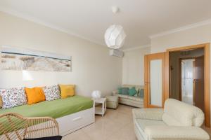 a living room with a bed and a couch at Villa Marquez Apartments in Vila Real de Santo António