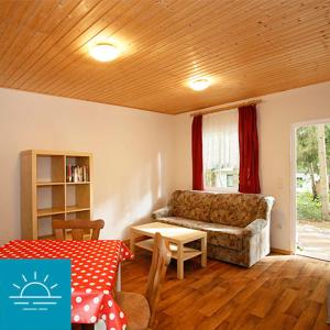 ein Wohnzimmer mit einem Sofa und einem Tisch in der Unterkunft Bungalow SONNE UND MEER direkt am Strand in Dranske