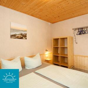 1 dormitorio con cama y estante para libros en Bungalow SONNE UND MEER direkt am Strand en Dranske
