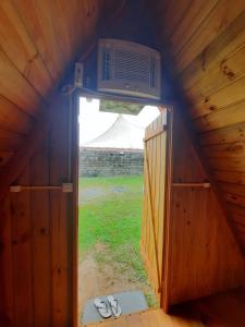an open door into a wooden house with a tv on top at Cabana com Ar condicionado e area de cozinha e banheiro compartilhado a 10 minutos do Parque Beto Carrero in Penha