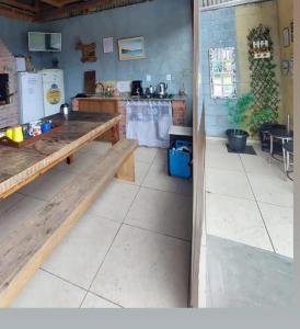 uma cozinha com um banco de madeira e uma mesa em Cabana com Ar condicionado e area de cozinha e banheiro compartilhado a 10 minutos do Parque Beto Carrero em Penha