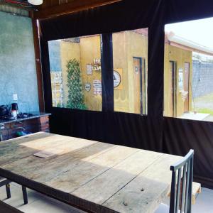 a wooden table in a room with a large window at Cabana com Ar condicionado e area de cozinha e banheiro compartilhado a 10 minutos do Parque Beto Carrero in Penha