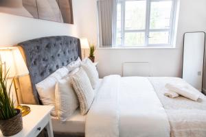 1 dormitorio con cama blanca y ventana en Cozy Townhouse in the heart of Greater Manchester en Mánchester
