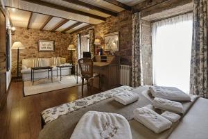 a bedroom with a bed and a desk and a room at Hotel Rustico Lugar Do Cotariño in Camariñas