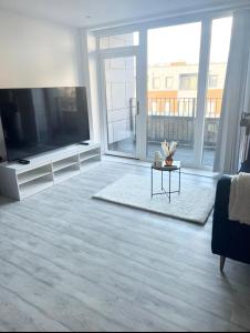 a living room with a large television and a table at Stylish Luxury new 2 bedroom Apartment in Dartford