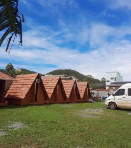 a row of houses with a white van parked in front at Cabana com Ar condicionado e area de cozinha e banheiro compartilhado a 10 minutos do Parque Beto Carrero in Penha