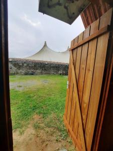 a view of a tent from a wooden door at Cabana com Ar condicionado e area de cozinha e banheiro compartilhado a 10 minutos do Parque Beto Carrero in Penha