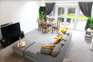 a living room with a couch and a dining room at Cozy Townhouse in the heart of Greater Manchester in Manchester