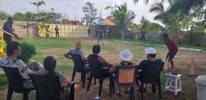 a group of people sitting in chairs watching a baseball game at SAMARA SEAVIEW in Alibag