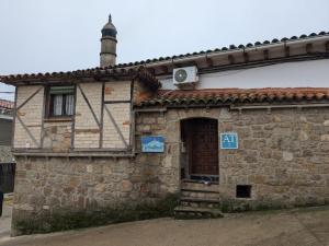 un antiguo edificio de piedra con puerta y ventana en Apartamento Turístico Monteceli, en Gata